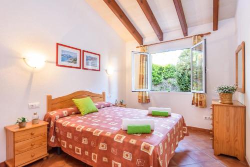 un dormitorio con una cama y una ventana en Villa Mango by Villa Plus, en Cala'n Bosch