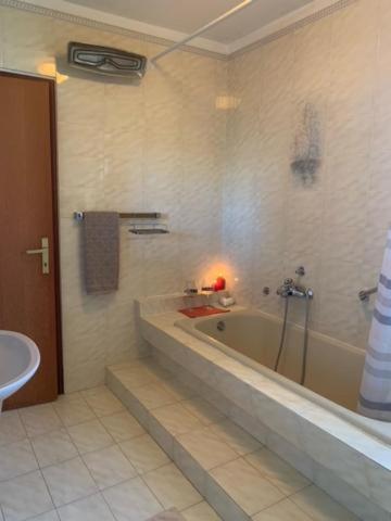 a bathroom with a bath tub and a sink at Romantic room for two persons in Poreč