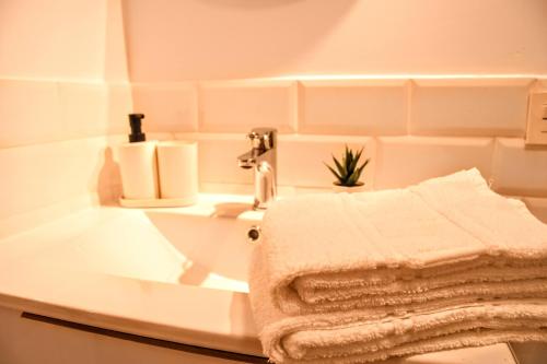 y baño con lavabo y toallas. en Arco da Vella apartamentos, en Villanueva de Arosa