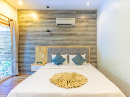 a bedroom with a bed with a wooden wall at Sara Resort in Koh Rong Sanloem