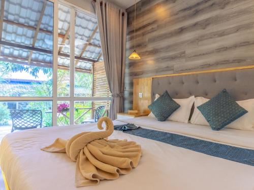 a bedroom with a bed with a towel on it at Sara Resort in Koh Rong Sanloem