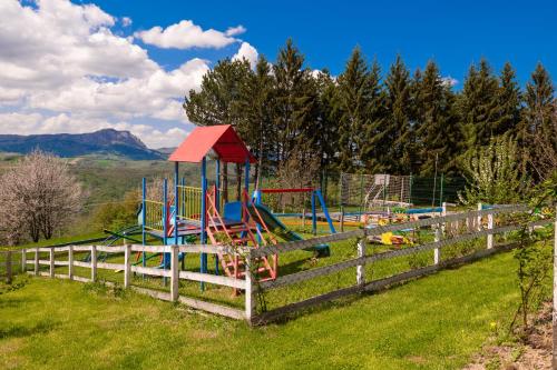 un parque infantil en un campo junto a una valla en Vila Angelina, en Kušići