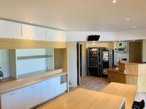 a kitchen with white cabinets and a wooden table at Lemon Hotel Plan de Campagne Marseille in Septèmes-les-Vallons