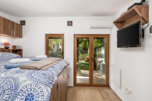 a bedroom with a bed and a flat screen tv at Cute & Green in Opatija