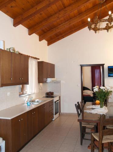 a kitchen with wooden cabinets and a table and a dining room at Villa Internity in Alikampos