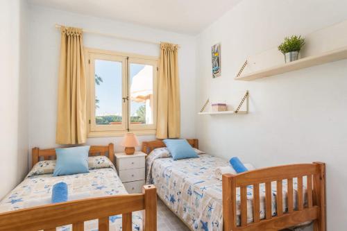 ein Schlafzimmer mit zwei Betten und einem Fenster in der Unterkunft Villa Vera by Villa Plus in Cala'n Bosch