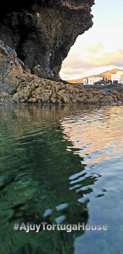 a body of water next to a rocky shore at Ajuy Tortuga House in Ajuy