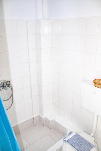 a white bathroom with a tub and a toilet at Bob's Apartments in Tolo