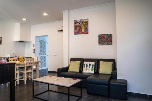 een woonkamer met twee zwarte stoelen en een tafel bij Casa Terraço in Fuzeta