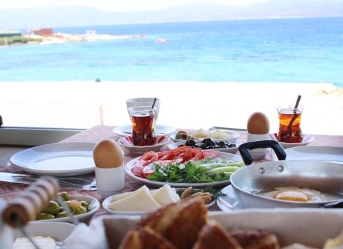 uma mesa com comida e vista para o oceano em Akkum Beach Otel em Seferihisar