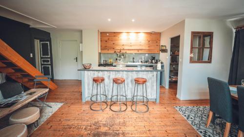 a kitchen with a counter and stools in a room at Gîte La Source in Grusse
