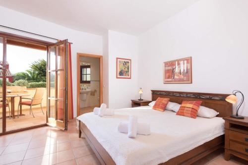 a bedroom with two beds and a balcony with a table at Villa Xoric by Villa Plus in Son Xoriguer