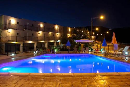 una gran piscina frente a un edificio por la noche en Panoramic Holidays - Deluxe 6, en Peyia