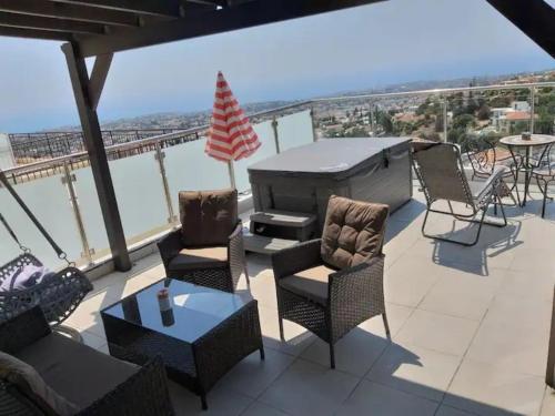 a patio with chairs and a grill on a balcony at Panoramic Holidays - Deluxe 6 in Peyia