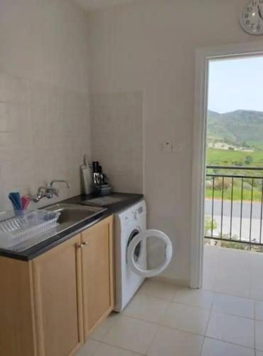 a kitchen with a sink and a washing machine at Panoramic Holidays - Deluxe 6 in Peyia