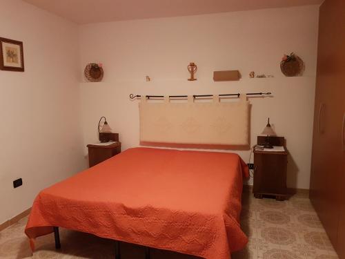 Villanova MonteleoneにあるStanze private ARIANNAのベッドルーム1室(オレンジ色のベッドカバー付)