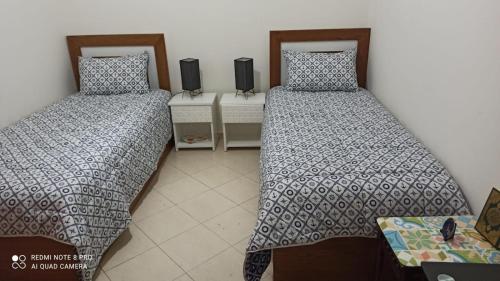 a room with two beds and a table at Al Kawtar in Mohammedia
