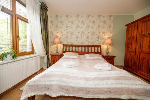a bedroom with a bed with two towels on it at Penzion Sonáta in Luhačovice