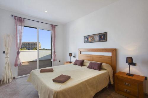 a bedroom with a large bed and a large window at Villa Natasha by Villa Plus in Cala en Forcat