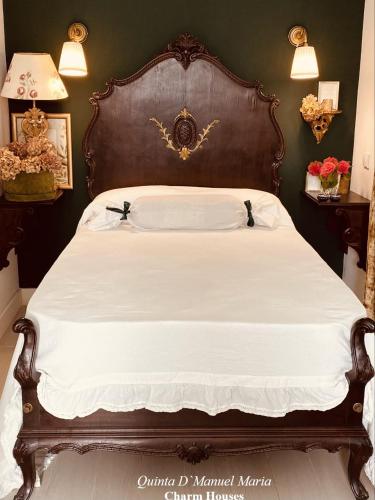 a large bed with a wooden headboard in a bedroom at Amarante-Quinta D’Manuel Maria, Rural Charm Houses in Amarante