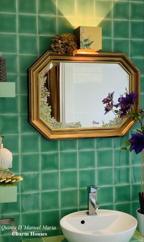 a green tiled bathroom with a sink and a mirror at Amarante-Quinta D’Manuel Maria, Rural Charm Houses in Amarante