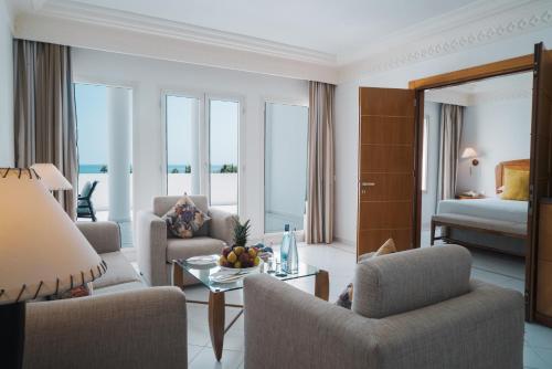 a living room with chairs and a table and a bed at Marina Smir Hotel & Spa in M'diq