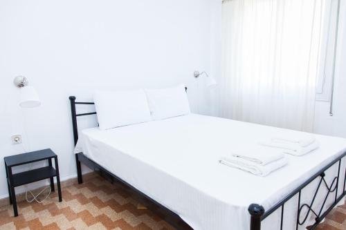 een groot wit bed in een kamer met een stoel bij Beautifull Apartment in Piraeus in Piraeus