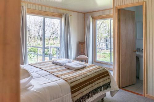 ein Schlafzimmer mit einem Bett und einem großen Fenster in der Unterkunft La Casona, Baño Privado in Villa Cerro Castillo