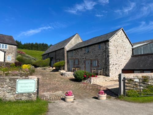 a row of stone buildings with a sign in front at The Granary at Pentregaer Ucha, tennis court & lake. in Oswestry