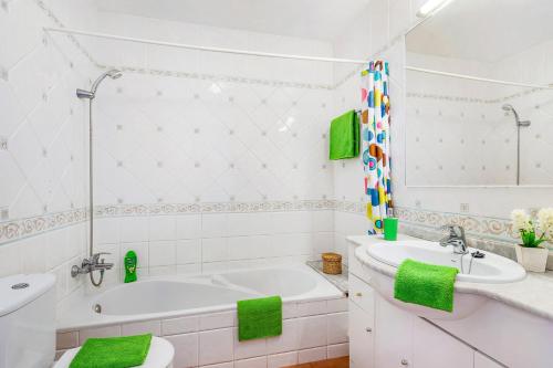 La salle de bains blanche est pourvue d'une baignoire et d'un lavabo. dans l'établissement Villa Orca by Villa Plus, à Cala en Forcat