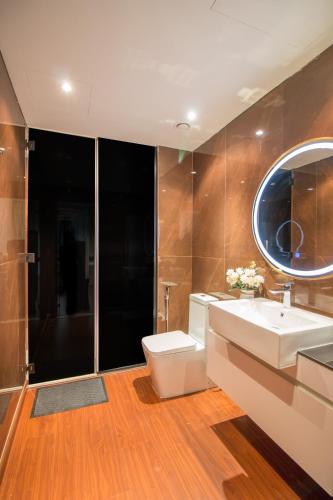 a bathroom with a sink and a toilet and a mirror at Luxurious 2BR - Fully Upgraded - High-end facilities in Dubai