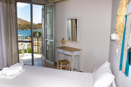 a bedroom with a bed and a view of the ocean at Bob's Apartments in Tolo