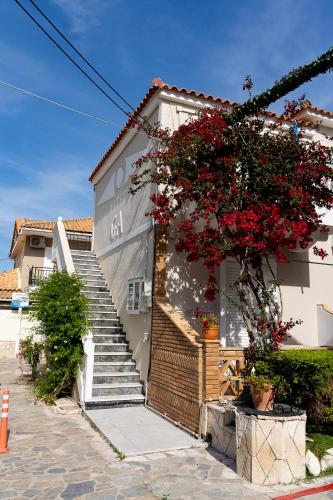 a house with red flowers on the side of it at Asteri Studios in Kalamaki