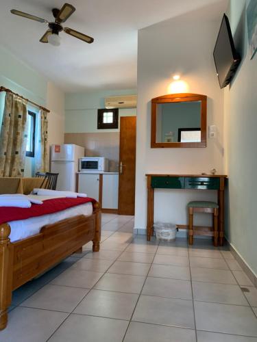 - une chambre avec un lit et un bureau dans l'établissement Filoxenia Studios, à Skliri