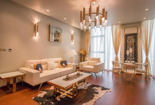 a living room with white furniture and a chandelier at Luxurious 2BR - Fully Upgraded - High-end facilities in Dubai
