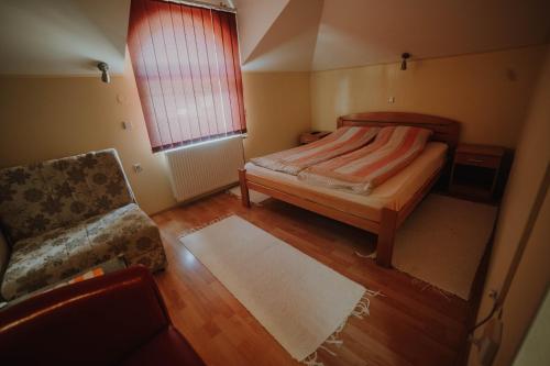a small bedroom with a bed and a chair at Vila Angelina in Kušići