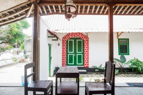 a table and chairs in front of a house at RedDoorz Syariah @ Ndalem Kembang Sore Yogyakarta in Timuran