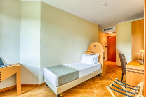 a bedroom with a bed and a desk and a chair at Hotel PentHouse in Perugia