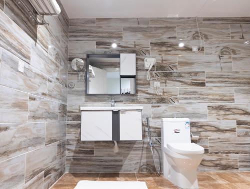 a bathroom with a toilet and a sink and a mirror at Garden View Suites in Tabuk