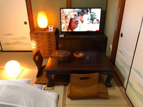 a living room with a tv and a table in a room at Tomo's INN - priceless experience - in Obu