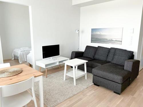a living room with a couch and a table at Kotimaailma Apartments Oulu in Oulu