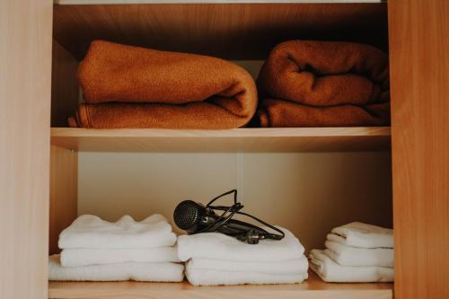 a closet with towels and a microphone and towels at Vila Angelina in Kušići