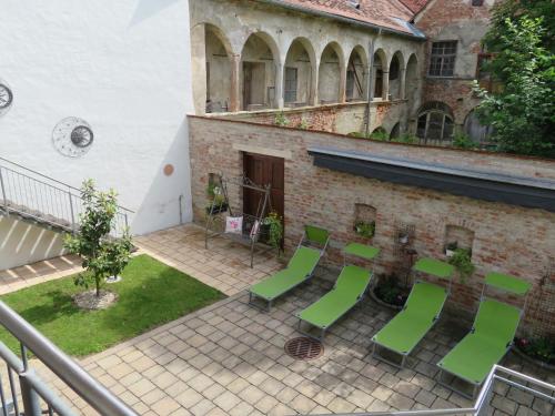 a group of green chairs sitting outside of a building at Bürgerhaus Martinecz in Bad Radkersburg