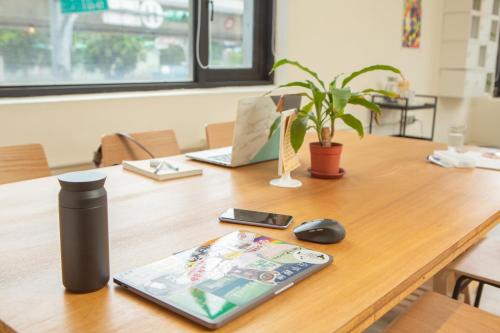 a table with a cell phone and a computer mouse at Corner Hostel & Cafe in Taipei
