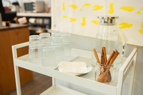 a glass table with glasses and a bottle on it at Corner Hostel & Cafe in Taipei
