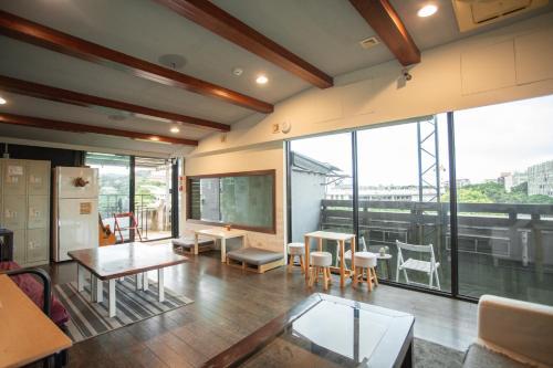 a room with tables and chairs and a large window at Corner Hostel & Cafe in Taipei