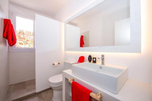 a white bathroom with a sink and a toilet at Villa Aguamarina by Villa Plus in Cala en Forcat