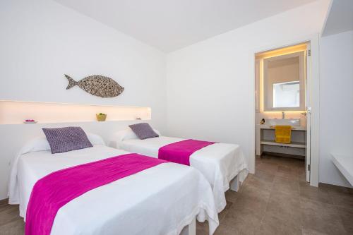two beds in a white room with a sink at Villa Aguamarina by Villa Plus in Cala en Forcat