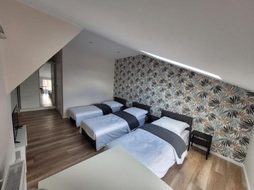 a bedroom with four beds and a wall with a pattern at RYNEK 2 DUKLA- POKOJE I APARTAMENTY in Dukla