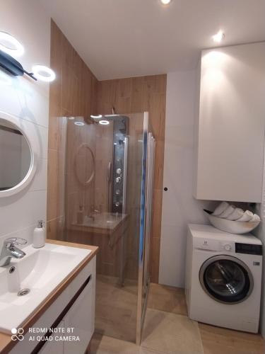 a bathroom with a shower and a washing machine at Apartament blisko dwóch jezior na Warmii i Mazurach in Biskupiec